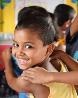 A close-up of a child smiling in a Play Lab in Bangladesh