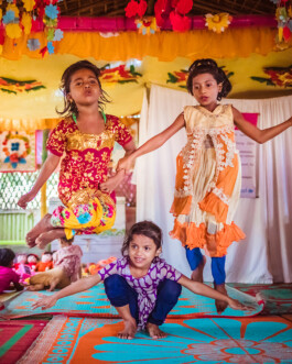 Two girls jump over a third child during a game at a Play Lab in Bangladesh